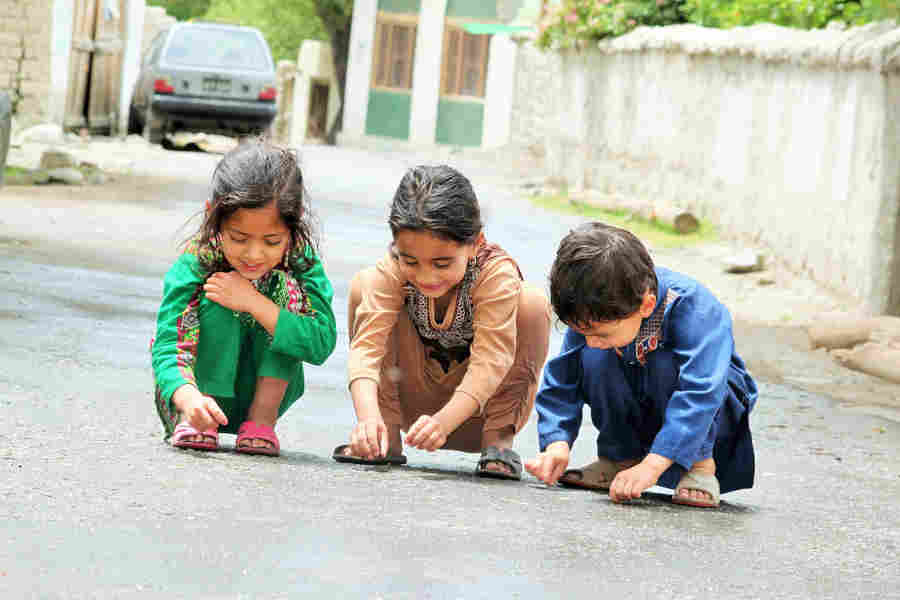 three-young-cousins-happily-playing-by-sitting-on-the-road