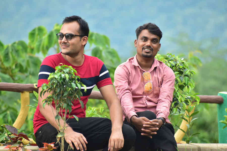 two-indian-male-friends-happily-sitting-outside-in-the-nature