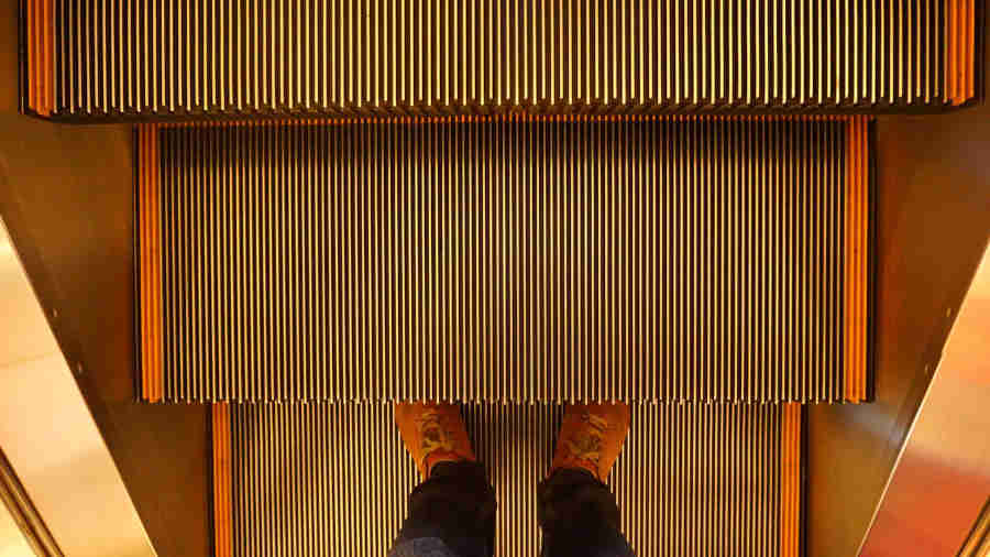 photo-of-foot-of-a-person-standing-on-an-escalator.